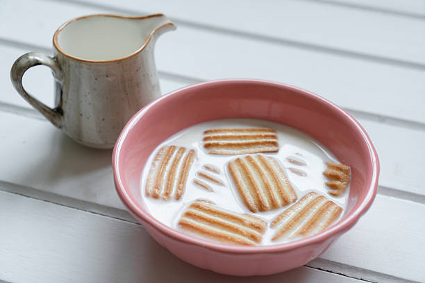 Baby biscuit with milk in white bowl