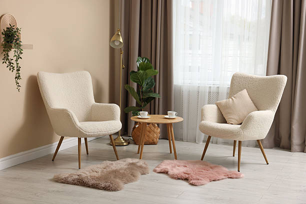 istock Soft armchairs and coffee table near beige wall indoors 2228177044