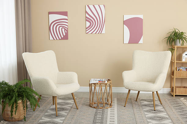 istock Soft armchairs and coffee table near beige wall indoors 2228177079