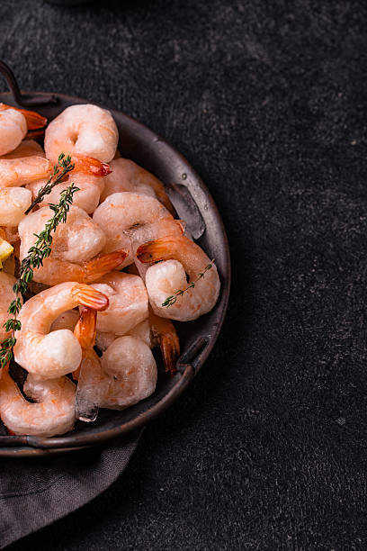 istock Frozen uncooked prawns or shrimps with lemon 2228177677