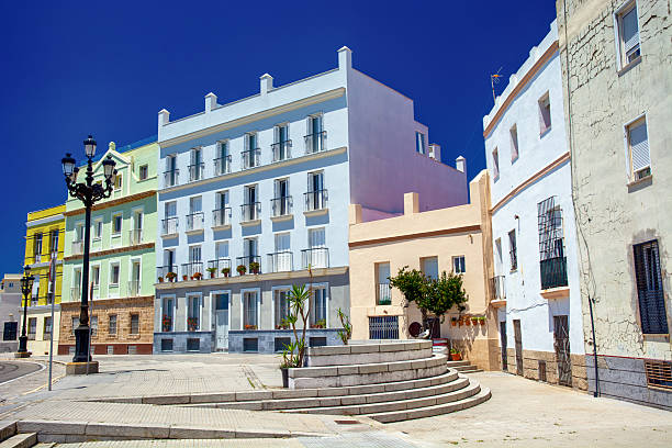 Colorful houses with facades in warm pastel tones brighten the old town of Cádiz, Spain