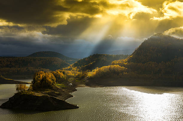 Majestic autumn mountains glow beneath heavenly sunlight streaming through clouds. Captured at Hoheikyo Gorge, this landscape inspires awe, wonder, and reflection in natureâs silence.
