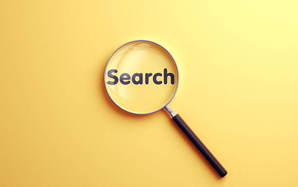 istock Search Text Selected with Metallic Magnifying Glass on Soft Blue Background 2228183801