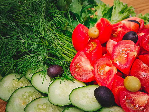 Fresh cucumbers, tomatoes and greens. Close-up, selective focus.