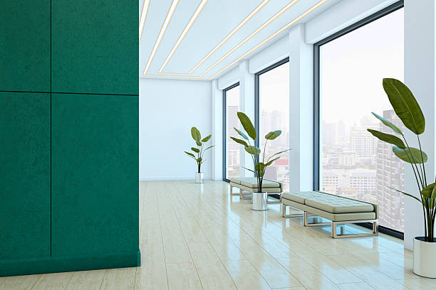 istock Modern corporate hallway with large windows, green wall panel, benches, and potted plants overlooking city skyline in bright indoor setting. 3D Rendering 2228184079