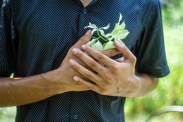 A young man shows White flower in his pocket