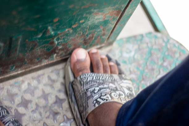 A young man shows his leg on the ground