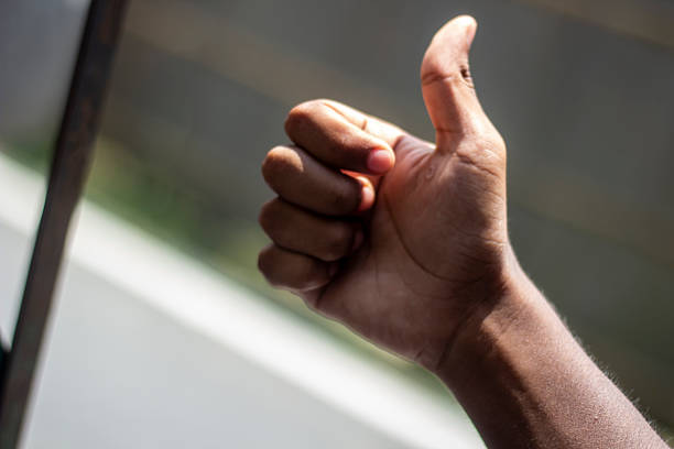 istock A man's hand pointing the thumb up and blur background 2228188318