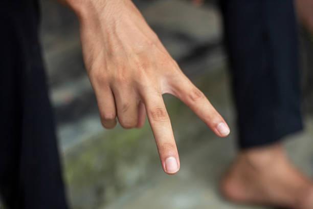 istock A man pointing two fingers of his hand forward and green background 2228188355