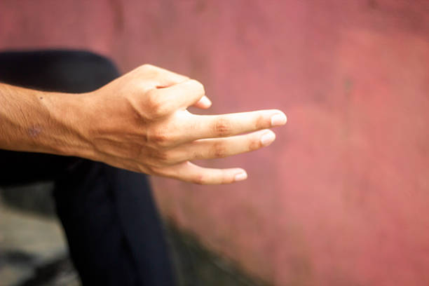 A man pointing his three fingers forward and blurred background