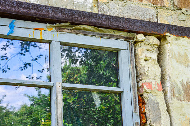 istock Old stone wall with rustic wooden window reflecting greenery, evoking rural charm and decay. Themes: countryside, nostalgia, rustic architecture, decay, reflection 2228194966