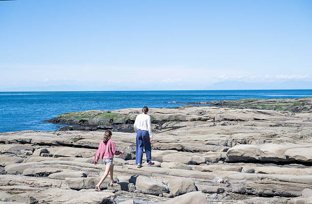 Sisters explore rocky shoreline in summer, Pender Island, Gulf Islands