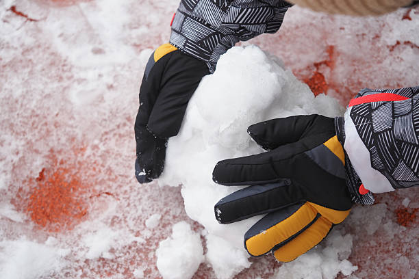 istock Child building a snowball during winter playtime outside 2228197387