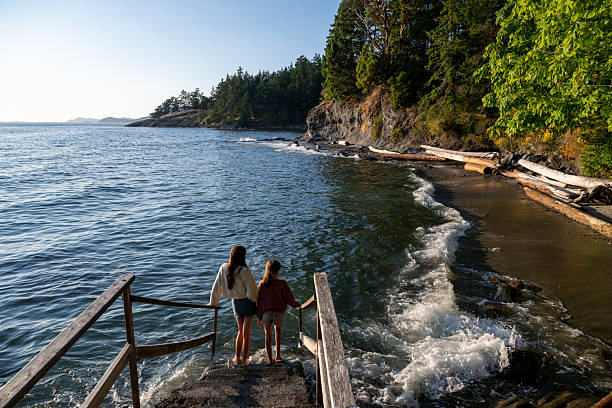 istock Sisters walk down steps to the ocean at sunset 2228197838