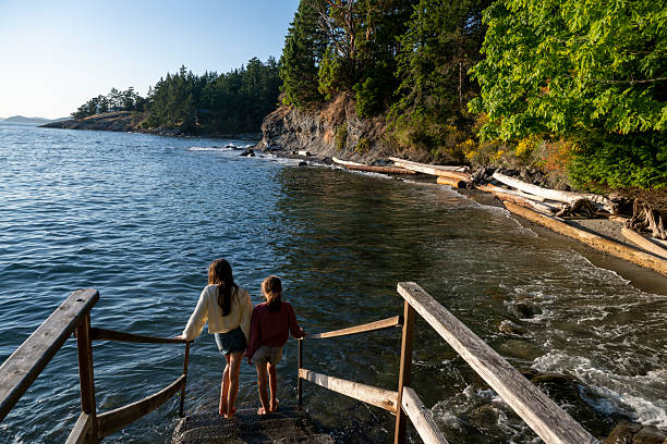 istock Sisters walk down steps to the ocean at sunset 2228197929