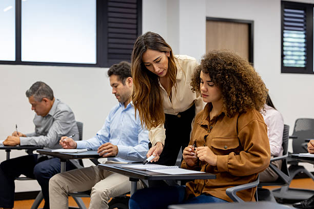 istock Teacher talking to a female student sitting at her desk in class 2228200286