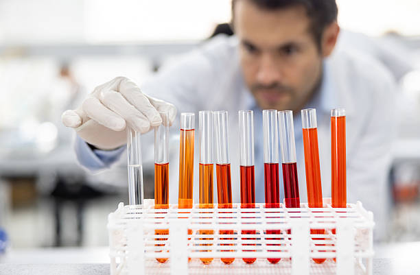 Latin American doctor holding a test tube at the laboratory while doing medical tests - focus on foreground