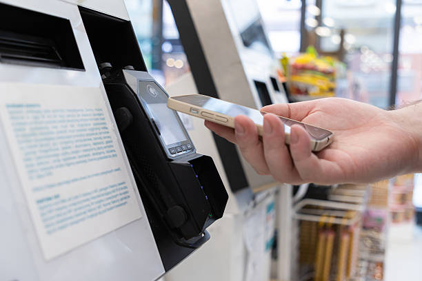 istock Person using a smartphone for fast contactless payment at a retail store self-checkout terminal, symbolizing modern digital transaction processes 2228205502