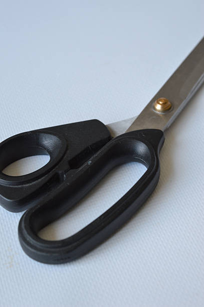 istock hand holding large metal scissors with black handle ideal for themes like sewing, crafting, cutting, DIY projects, tailoring, textile work, or home office supplies 2228205613