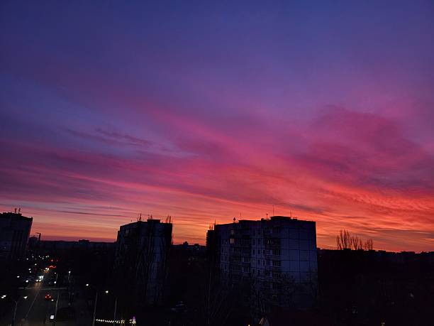 Bright red-pink sunset resembling a gradient over gray buildings in the city