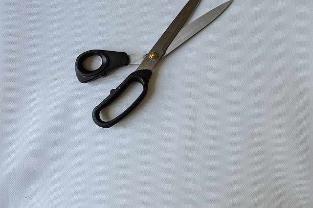 istock hand holding large metal scissors with black handle ideal for themes like sewing, crafting, cutting, DIY projects, tailoring, textile work, or home office supplies 2228205683