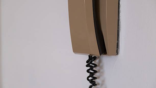 istock Vintage beige wall-mounted intercom phone with coiled cord 2228207793