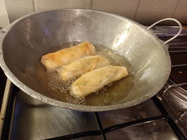 istock spring rolls deep fried in a wok. food preparation 2228211684