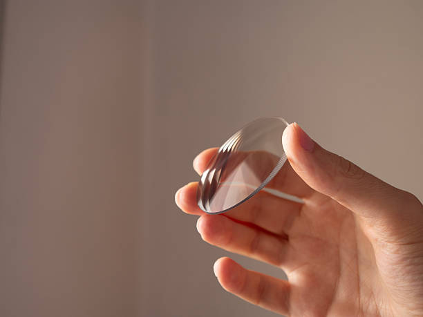 istock Hand holding a transparent glass eyeglasses lens 2228213509