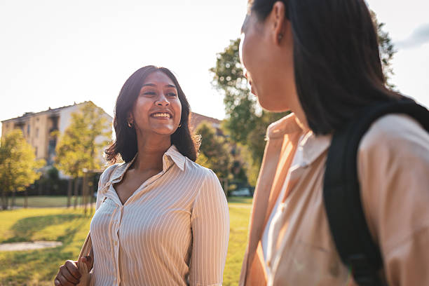 istock Two young female students walking and talking together outdoors 2228229021