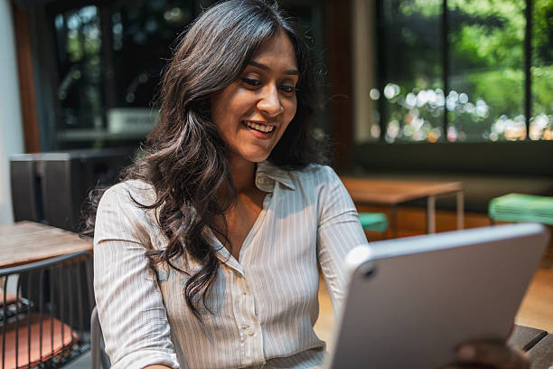 istock Young indian businesswoman smiling and using tablet in a cafe 2228229381