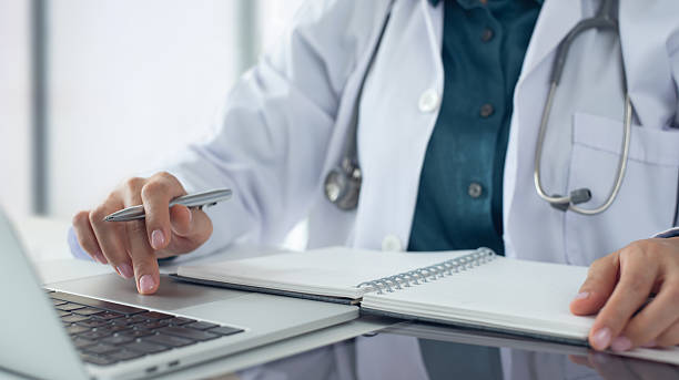 istock Medical student using laptop computer in research education. Internship doctor searching the information at doctor's office, medical research. Healthcare and medicine, closeup 2228232324
