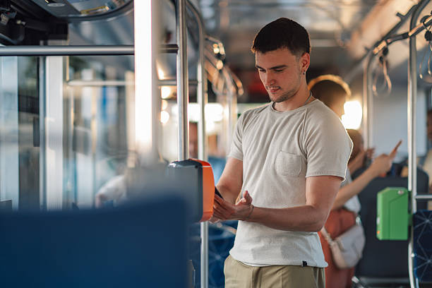 istock Young man paying contactless with smartphone on bus 2228233837
