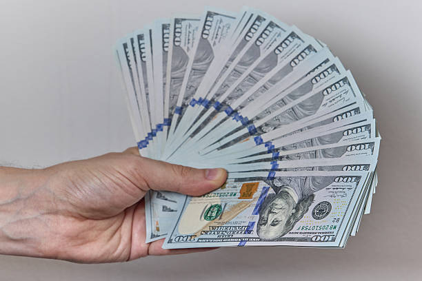 istock Hand Holding US Dollar Banknotes on Neutral Background 2228233846