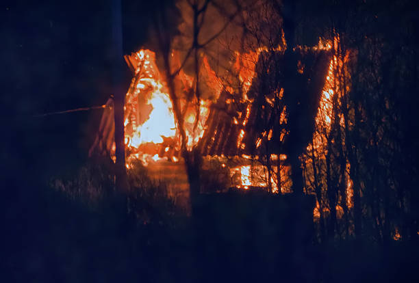 Blurred background. small wooden cottage on fire at night