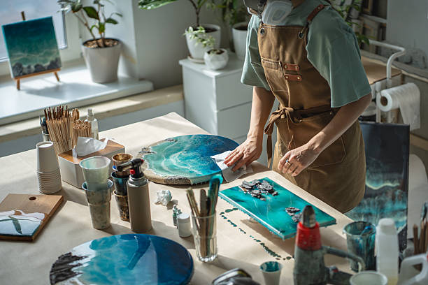 istock Female artist creating epoxy resin paintings on workbench equipped for professional creative work. 2228235851