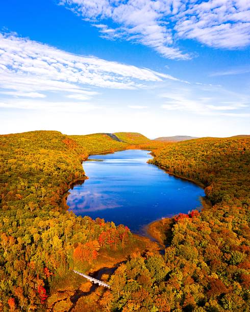 Overhead drone shot of Lake of the Clouds in Michigan, surrounded by vibrant autumn foliage.