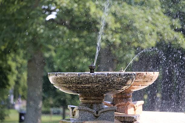istock Water Spraying from Two Stone Fountains basins in a Park 2228236452