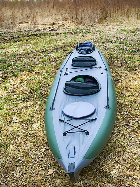 kayaks moored on shore of pond in grass in spring. walking on water outside city