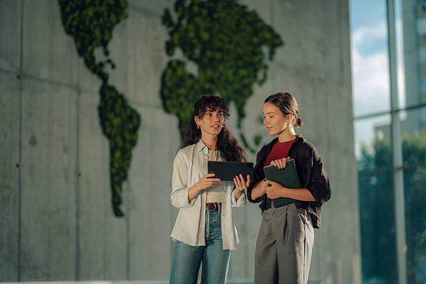 istock Two young businesswomen discussing over digital tablet in modern office 2228240423