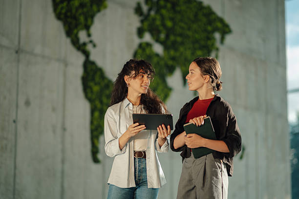 istock Two young businesswomen discussing a project using digital tablet and notebook 2228240430