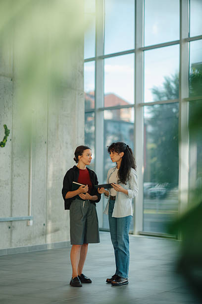 istock Two young businesswomen discussing a project in a modern office 2228240443