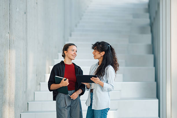 istock Two young businesswomen discussing a project using digital tablet and notebook 2228240486