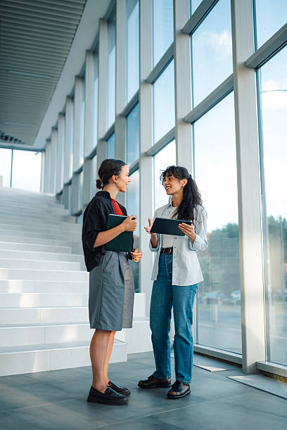 istock Two young businesswomen discussing work in modern office building 2228240491