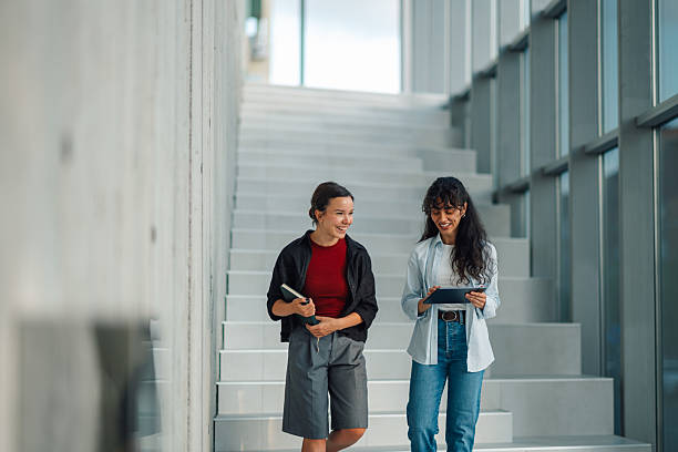 istock Two smiling students walking down stairs at university 2228240502