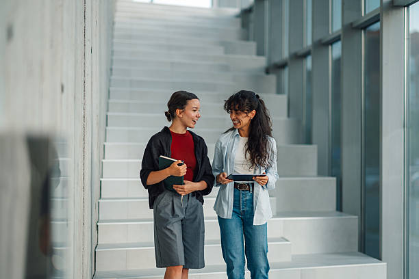 istock Two young female students walking and talking on university stairs 2228240503