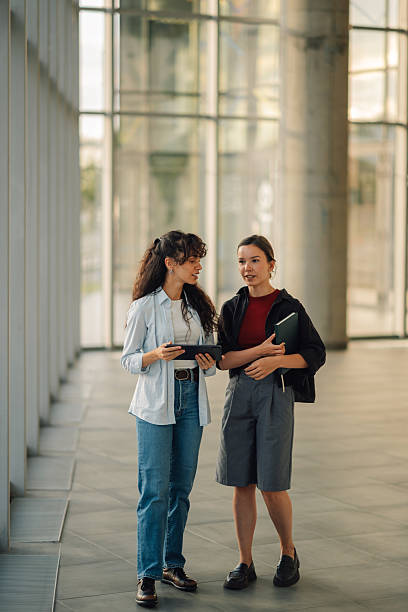istock Two young women collaborating on a project using a digital tablet in a modern office building 2228240526