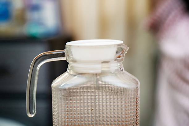 glass water carafe with white plastic lid. Simple hydration and kitchen essentials concept.