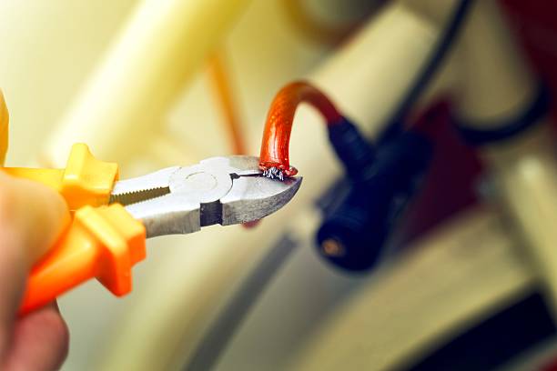 Cutting a red silicone-coated bicycle security cable with pliers, demonstrating anti-theft protection removal