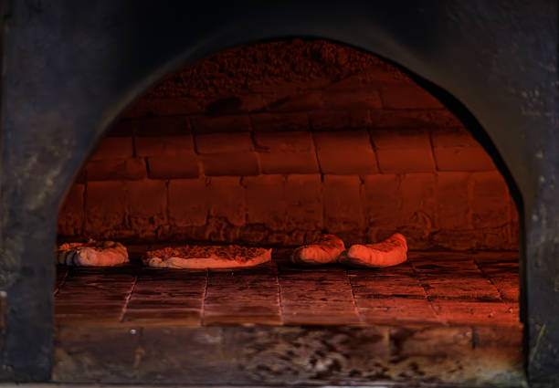Waiting for the Turkish pide to finish baking in a rustic wood burning stone oven, traditional food preparation, Istanbul, Turkey
