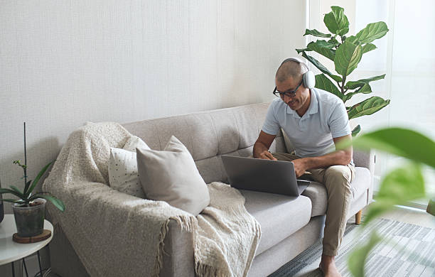 istock Focused employee working remotely from home office using laptop and headphones 2228243659